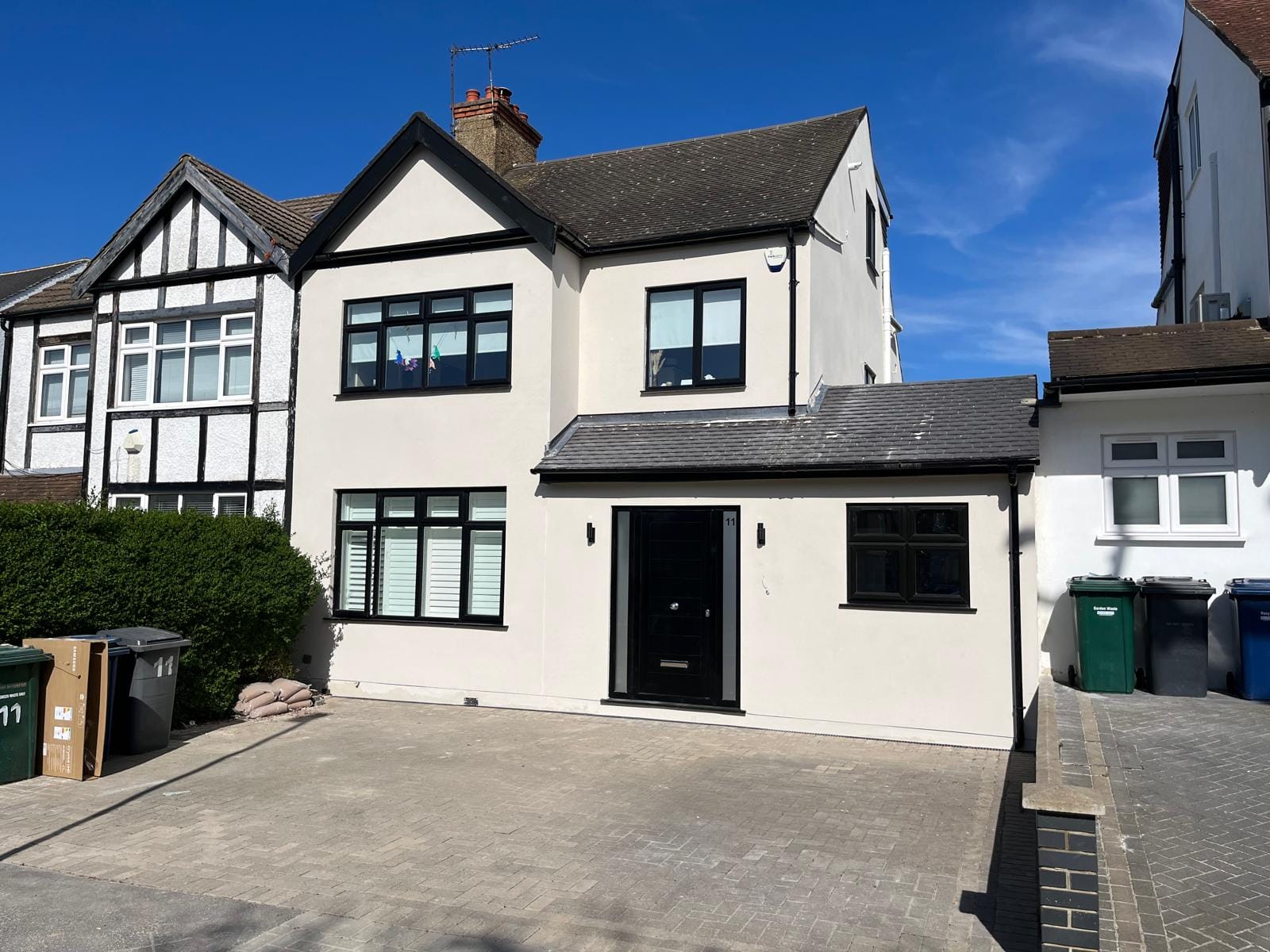 Finished residential house in North London with new monocouche render and black window frames.