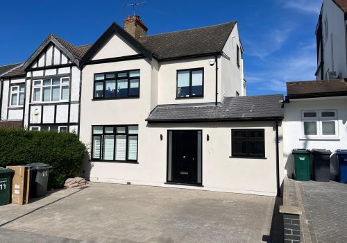 Finished residential house in North London with new monocouche render and black window frames.
